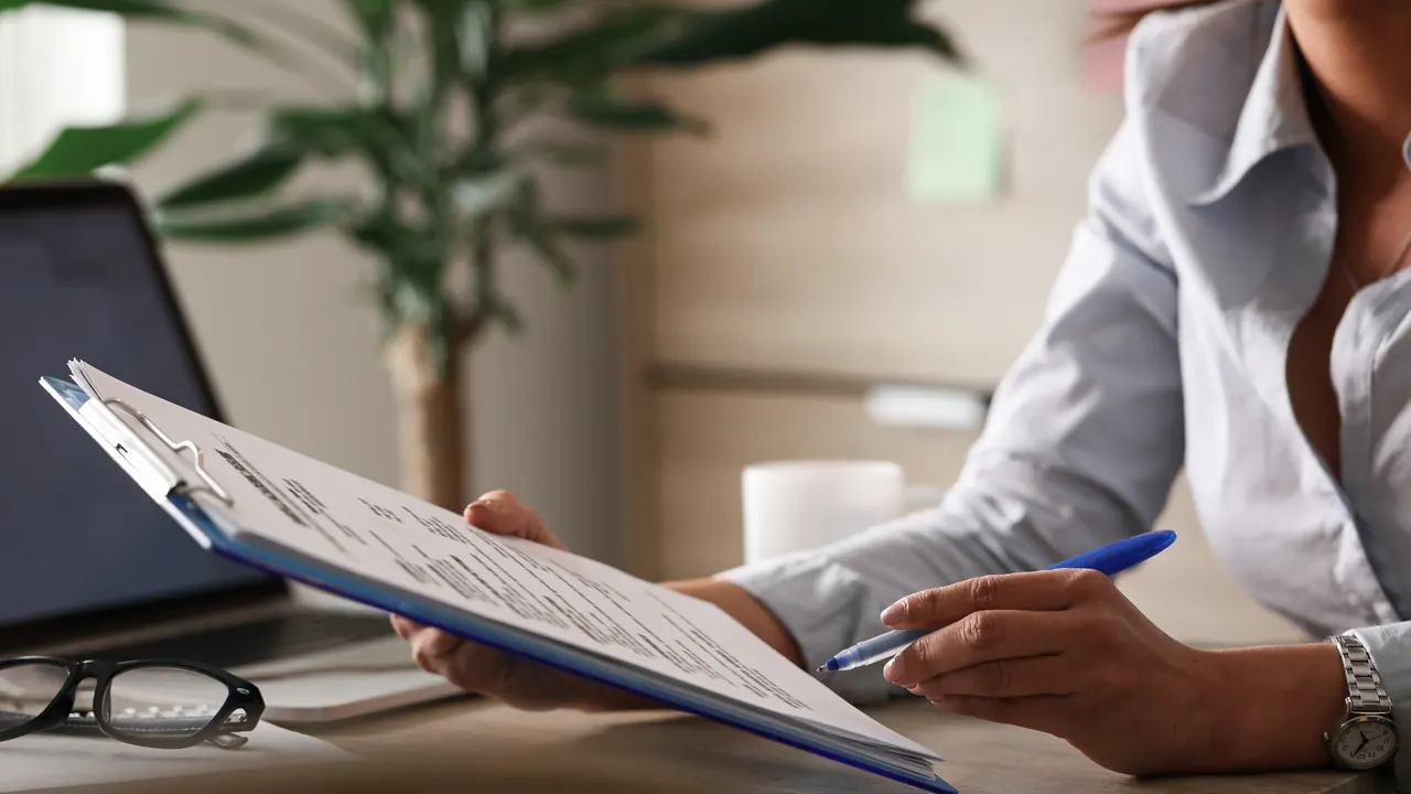 Reviewing reports on a clipboard in an office